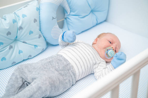 istock Sad baby lying in his crib sucking on pacifier 1212707927