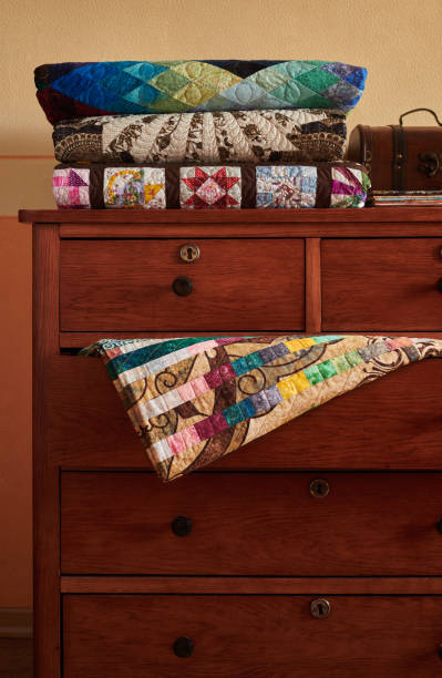istock Stack of traditional quilts on chest of drawers 1212708000