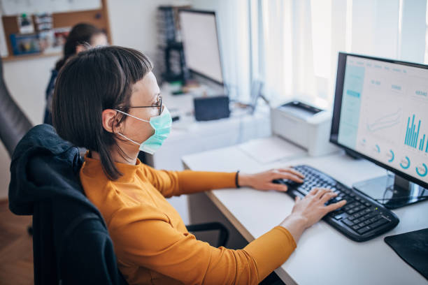 istock Female colleagues at work wearing face protective mask, to protecting themselves against corona virus 1212708016