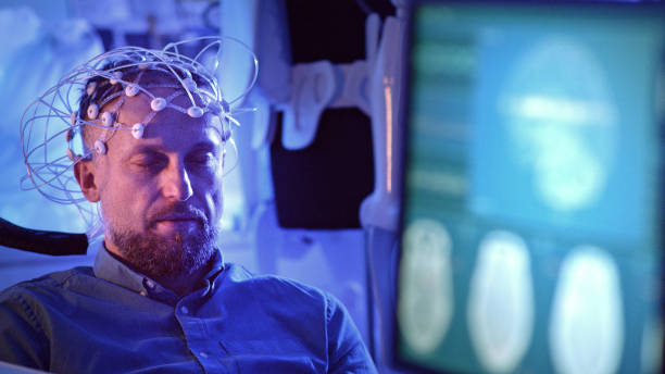 uomo che indossa un auricolare per la scansione delle onde cerebrali. - eeg foto e immagini stock