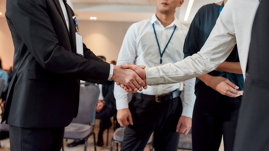 Diverse businesspeople having conversation standing together at meeting, men colleagues shaking hands at conference. Business, communication and education concept. Horizontal shot. Selective focus