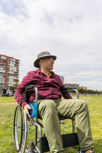 istock Man in wheelchair taking a walk in the park 1212708340