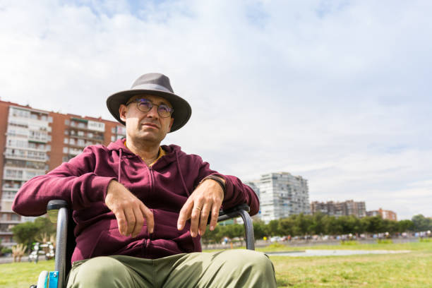 istock Man in wheelchair taking a walk in the park 1212708345