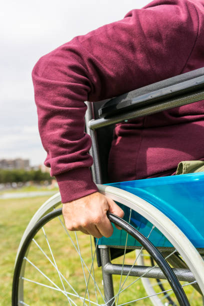 istock Man in wheelchair taking a walk in the park 1212708348