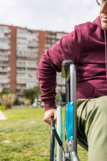 istock Man in wheelchair taking a walk in the park 1212708362