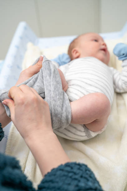 istock Female hands dressing baby boy pants 1212708534