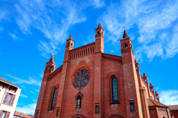 View of San Lorenzo cathedral under beautiful sky with white clouds in Alba, Piedmont, Northern Italy.