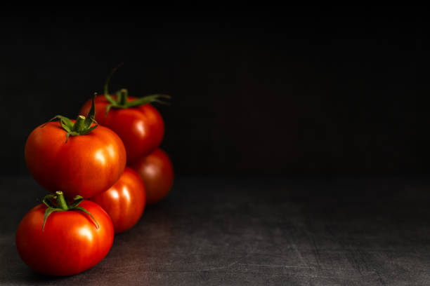 istock Fresh harvested tomato on a dark background 1212709781