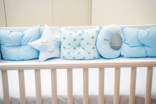 istock Cute baby crib with blue pillows 1212709788