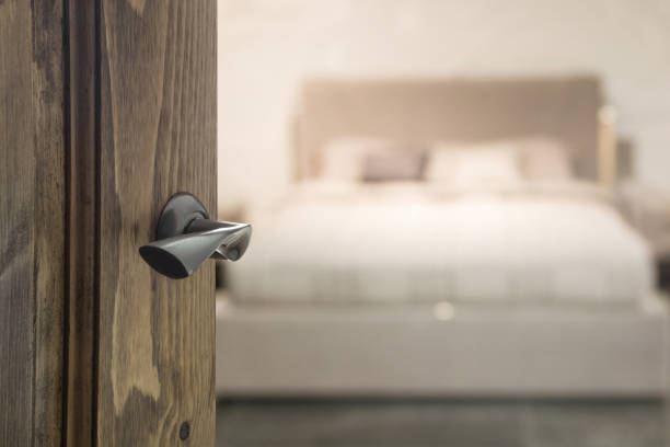 istock Open wooden door and view to bedroom. Blurred background. Abstract pattern. 1212710202
