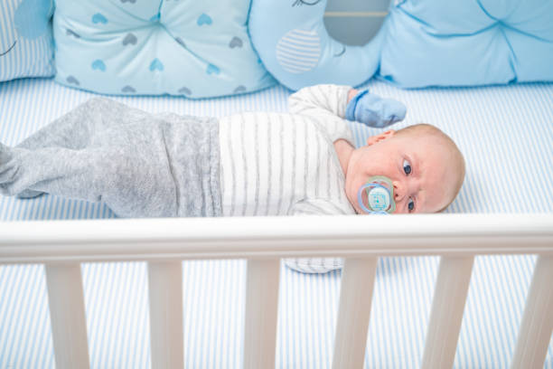 istock Baby lying in his crib sucking on pacifier 1212711428