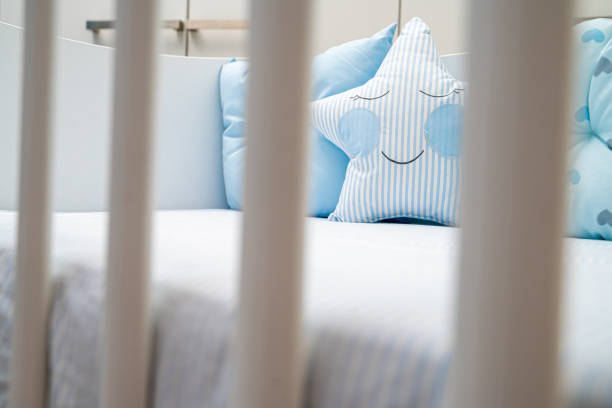 istock Cute blue pillows in baby boy crib 1212711663
