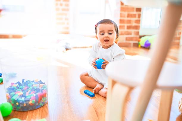 カラフルなおもちゃの周りの幼稚園で幸せな美しい幼児 - block child play toy ストックフォトと画像