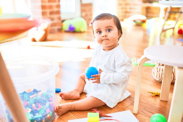 カラフルなおもちゃの周りの幼稚園で幸せな美しい幼児 - block child play toy ストックフォトと画像