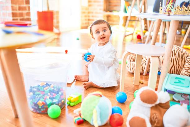 カラフルなおもちゃの周りの幼稚園で幸せな美しい幼児 - block child play toy ストックフォトと画像