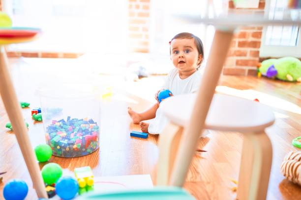 カラフルなおもちゃの周りの幼稚園で幸せな美しい幼児 - block child play toy ストックフォトと画像