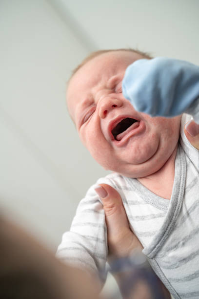 istock Mom holding her crying baby boy 1212712005