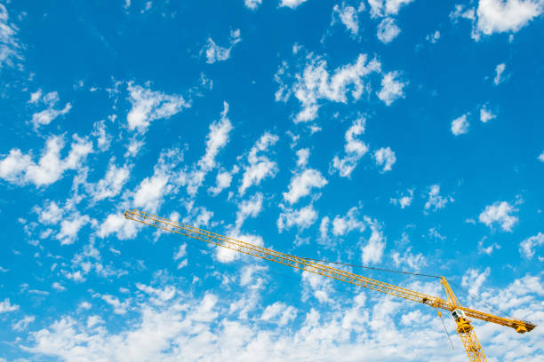 This is a photograph of a yellow construction crane with a clouds in a blue sky in New Orleans, Louisiana, USA.