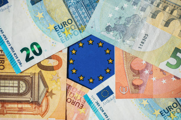 euro banknotes and european union flag - european union euro note european union currency paper currency currency imagens e fotografias de stock