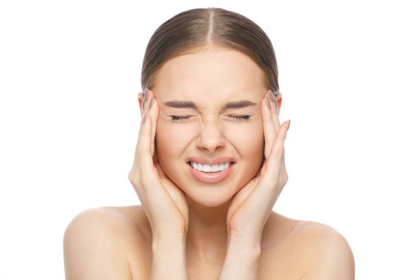 istock Upset unhappy young woman squeezing head with hands, suffering from headache, isolated on white background. People, stress, and migraine concept 1212721129