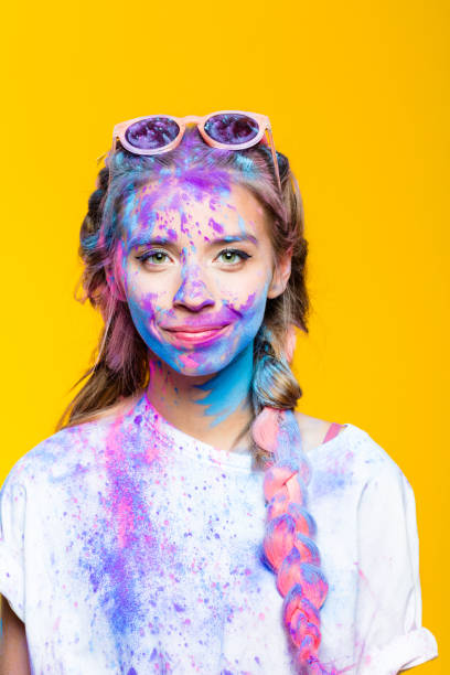 verticale de l’adolescente gaie célébrant le festival de holi - face powder photos et images de collection