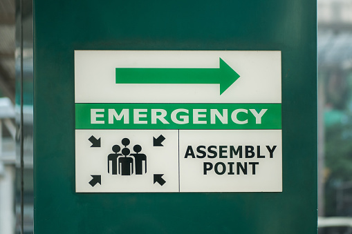 Emergency assembly point sign on the column of the building.