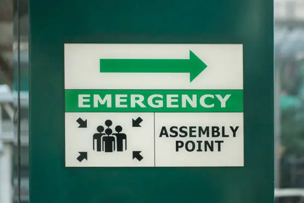 Emergency assembly point sign on the column of the building.