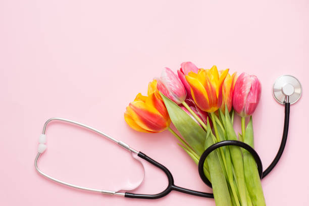 istock Stethoscope and colorful tulips on a pink background with a copy space 1212721861