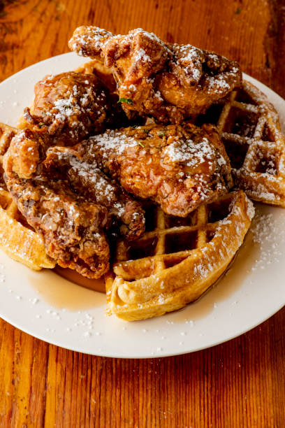 istock Chicken & waffles. Classic American Diner Style Breakfast or Brunch menu item favorite. Crispy homemade fried chicken on top of home buttermilk waffles topped with butter and maple syrup. 1212723064