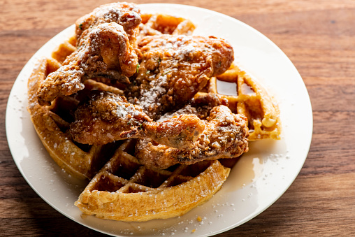 Fried chicken and waffles with berry butter and crispy southern fried chicken. Classic American breakfast or brunch favorite. Homemade waffles served with butter and maple syrup.