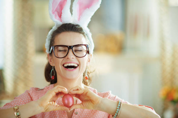 istock smiling modern woman with glasses showing egg 1212723249