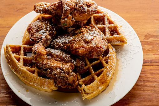 Fried chicken and waffles with berry butter and crispy southern fried chicken. Classic American breakfast or brunch favorite. Homemade waffles served with butter and maple syrup.