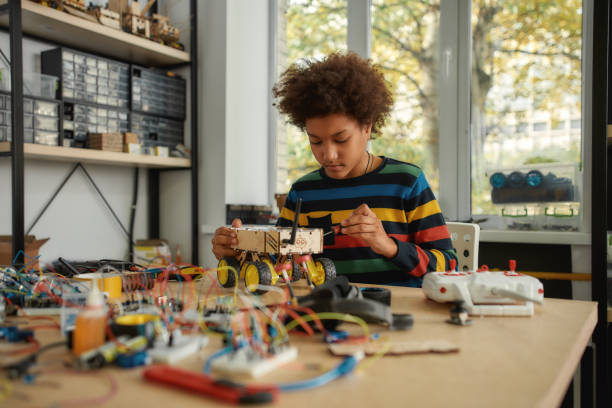 istock Do the right thing. Boy using screwdriver while fixing bolts on a robot vehicle. Smart kids and STEM education. 1212724575
