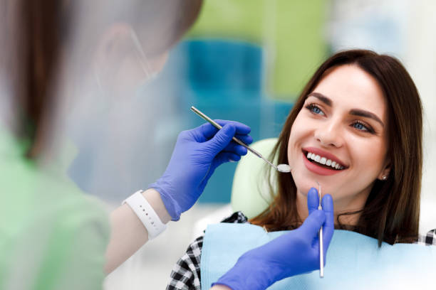 mulher sorridente na consulta do dentista. menina positiva bonita em um exame de rotina no dentista - smiling dentist office dentists chair women - fotografias e filmes do acervo