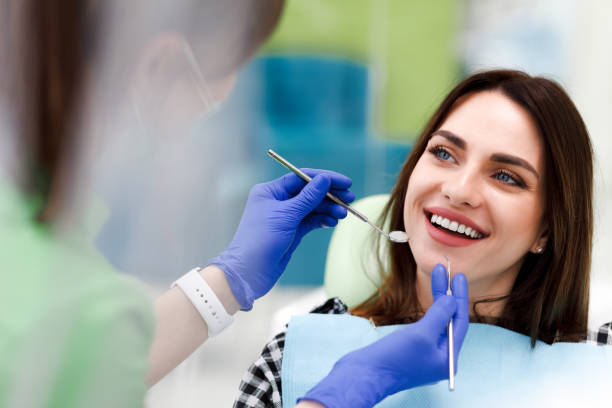 улыбающаяся женщина на приеме у дантиста. красивая позитивная девушка на обычном осмотре у стоматолога - smiling dentist office dentists chair women стоковые фото и изображения