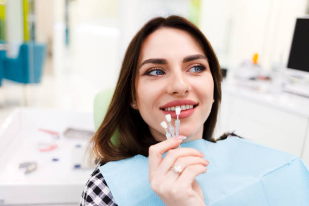 девушка выбирает цвет виниров в кабинете стоматолога - human teeth whitening dentist smiling стоковые фото и изображения