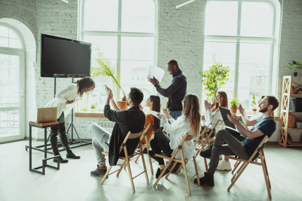 istock Female african-american speaker giving presentation in hall at university workshop 1212725411