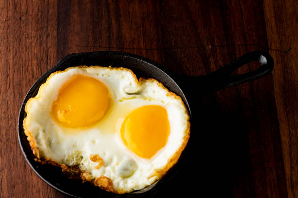 istock Fried eggs or sunny side up eggs served in mini cast iron skillet. 1212727139