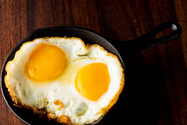 istock Fried eggs or sunny side up eggs served in mini cast iron skillet. 1212727166