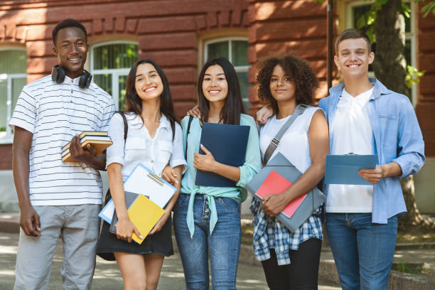 istock Group of happy international students posing over university background 1212727246