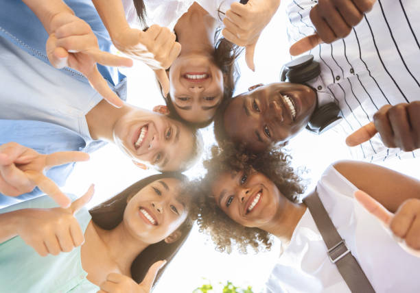 istock Joyful Multicultural Teenagers Standing In Circle, Showing Funny Gestures, Low Angle 1212728323