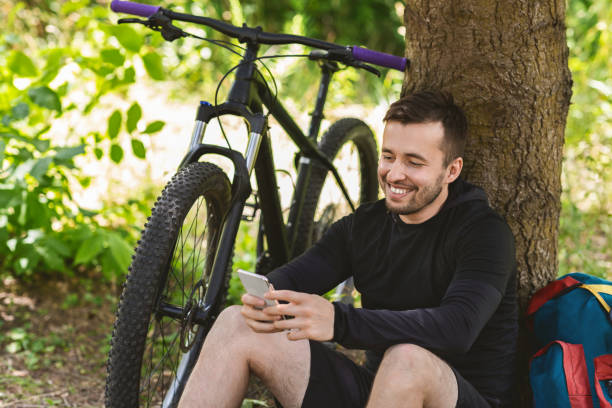 istock Happy man resting after cycling, holding phone 1212728428