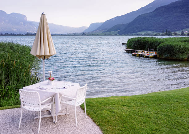 restaurante callejero de lujo con mantel blanco y flor en el lago caldaro en italia - lake caldaro fotografías e imágenes de stock