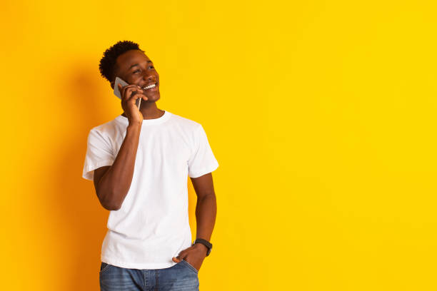 istock Young african guy talking by cell phone and smiling 1212729418