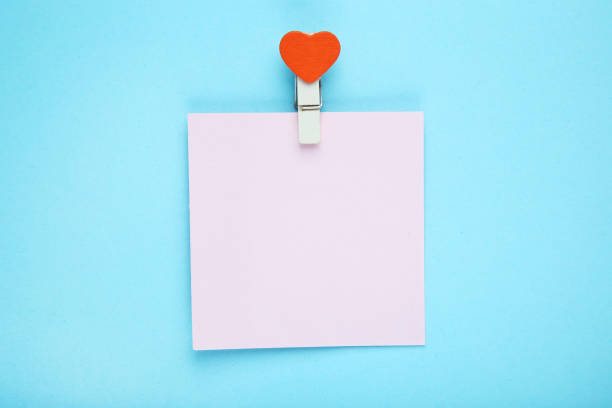 istock Paper sticky note with clothespin on blue background 1212730779