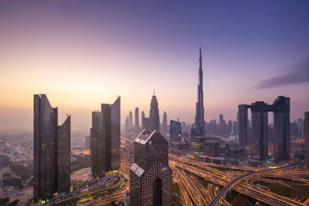 Urban skyline and cityscape at sunrise in Dubai UAE.