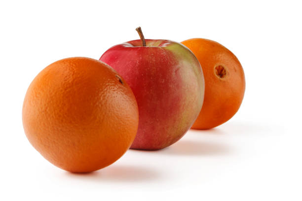 istock An orange and an Apple cut in half on a white background. 1212735249
