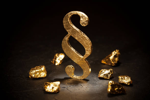 istock Gold paragraph sign and gold nuggets on black background. 1212740025