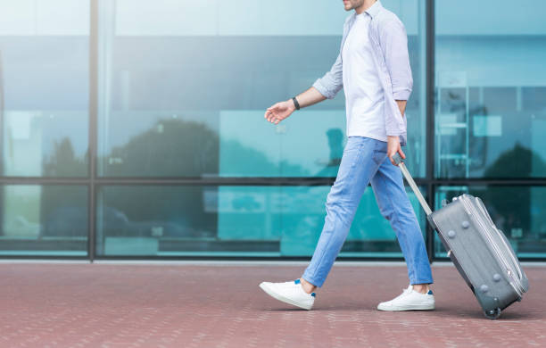 istock Going to terminal. Unrecognizable guy walking to airport with luggage 1212740390
