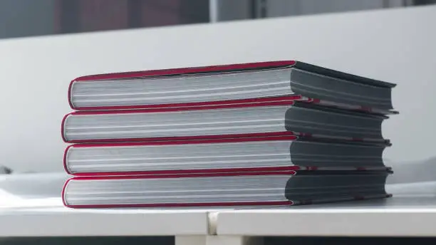 Photo of Four thick new books on a white table